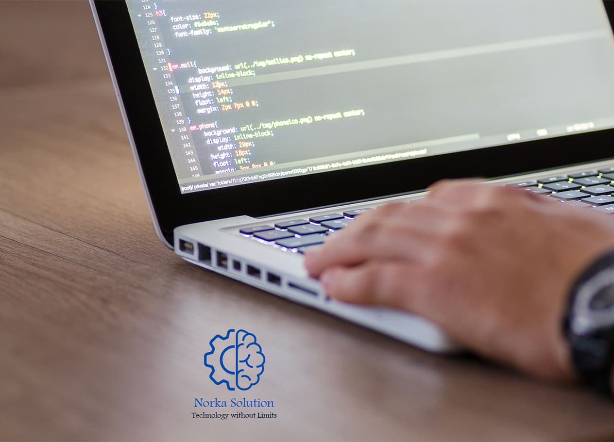 Close-up of a developer typing on a laptop showing code