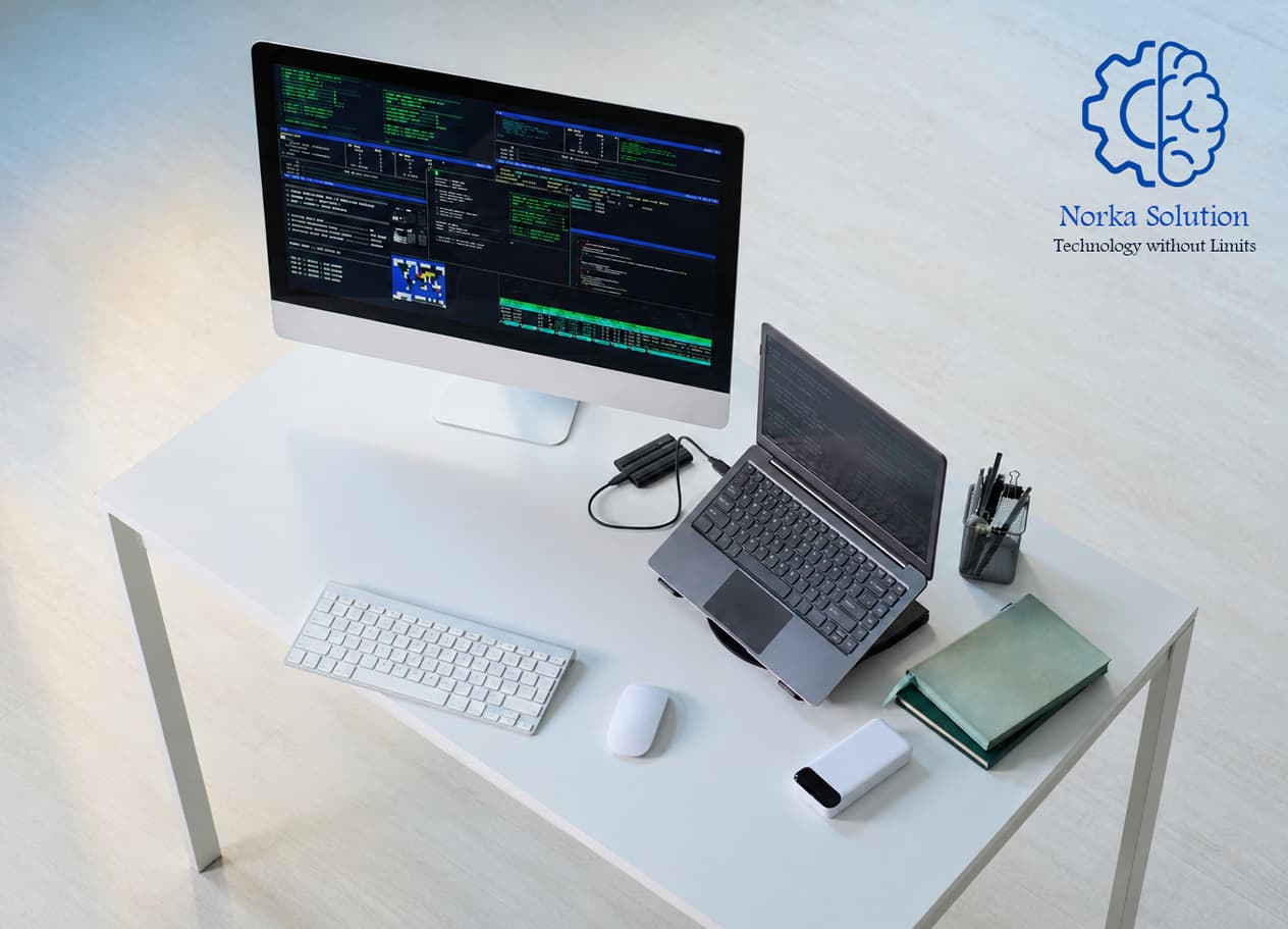 Developer workspace with a desktop monitor and laptop showing code